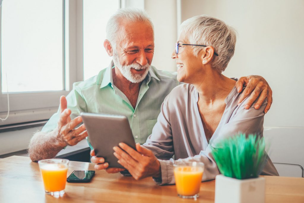 Elderly couple with mobile phone and digital tablet